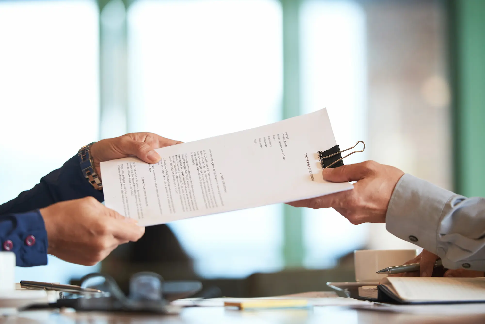 personnes dans un bureau qui font un échange de document rempli