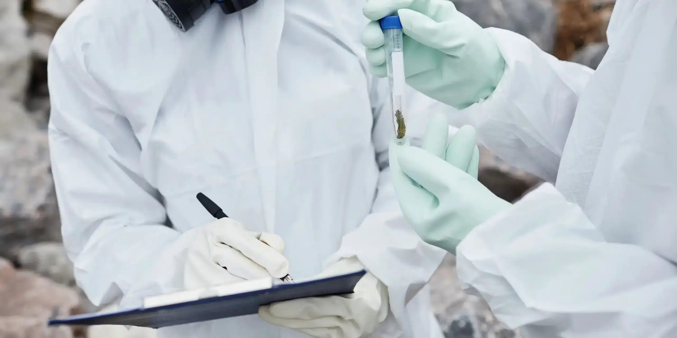 deux ingénieurs en environnement en chemise blanche avec des gants de protection qui réalise des prélèvements avec des échantillons et prennent des notes