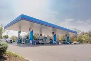 station service bleu en plaine journée avec des voitures qui font le plein